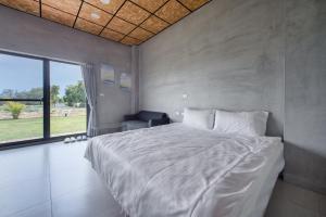 a bedroom with a large white bed and a window at 暮光島嶼 in Xiaoliuqiu