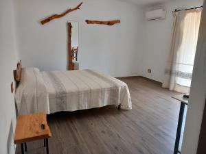 a bedroom with a bed and a wooden floor at Turismo Rurale Lu Stazzu Arzachena in Arzachena