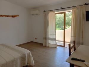 a bedroom with a bed and a large window at Turismo Rurale Lu Stazzu Arzachena in Arzachena
