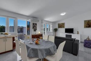 een eetkamer en een woonkamer met een tafel en stoelen bij Ana Apartment in Makarska