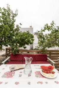 a table with a vase and a plate of watermelon at Amaranto Naxos 2 in Naxos Chora