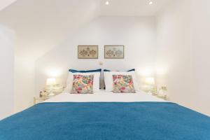 a bedroom with a white bed with blue sheets and pillows at Amaranto Naxos 2 in Naxos Chora