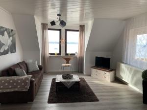 a living room with a couch and a tv at Ferienwohnung "Möltenorter Strand" in Heikendorf