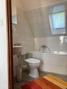 a bathroom with a toilet and a tub and a sink at Ferienwohnung "Möltenorter Strand" in Heikendorf