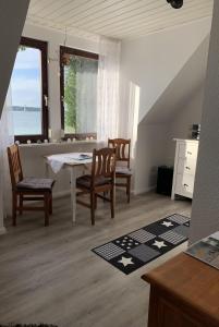 a dining room with a table and chairs and a window at Ferienwohnung "Möltenorter Strand" in Heikendorf +21 photos