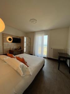 una camera da letto con un grande letto bianco e una finestra di Alba hotel a Saint Malo
