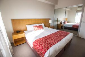 a hotel room with a large bed and a mirror at Gladstone Downtown Central Apartment Hotel Official in Gladstone