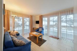 - un salon avec un canapé bleu et une table dans l'établissement Steinbilla 2 Bett Ferienwohnung, à Grindelwald