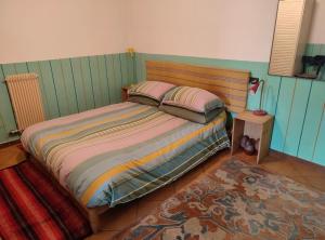 1 dormitorio con 1 cama con 2 almohadas y 1 alfombra en CASA PERMIRRA, en Feltre