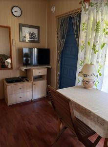 Pokój ze stołem z lampką i telewizorem w obiekcie Domek Ostróda w Ostródzie