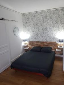 a bedroom with a bed and two lamps on two tables at Le studio du quai in Charleville-Mézières