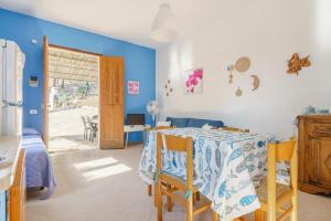 uma sala de jantar com uma mesa e cadeiras e paredes azuis em Villa La Pineta al Mare em Erice