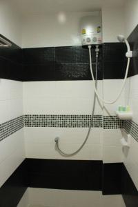 a bathroom with a shower with black and white tiles at Donmueang Airport Modern bangkok in Ban Ko