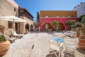 a courtyard with chairs and tables and a building at Saint Artemios Boutique Hotel in Rhodes Town