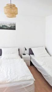 twee bedden in een kamer met witte muren bij Chic Apartment with Parking place in Apolda