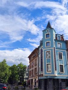 um edifício azul com uma torre em cima dele em Aurora Hills Hotel em Plovdiv