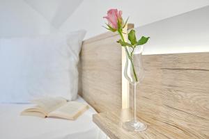 a rose in a vase on a table with a book at Ferienwohnung Popeye in Neddesitz