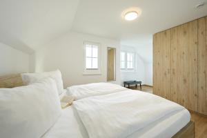 a white bedroom with a large bed with white sheets at Ferienwohnung Popeye in Neddesitz