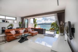 a living room with a couch and a tv at Atika Villa Patong in Patong Beach