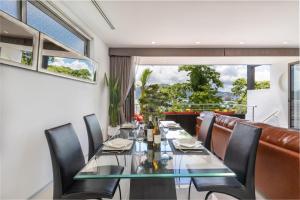 a dining room with a long glass table and leather chairs at Atika Villa Patong in Patong Beach