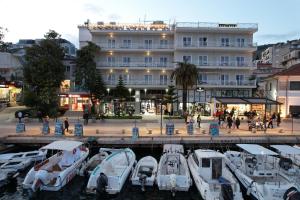 un gruppo di barche in un porto turistico di fronte a un edificio di Porto Eda Hotel a Sarandë