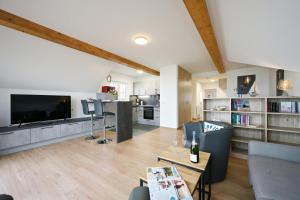 a living room with a large television and a kitchen at Ferienwohnung Popeye in Neddesitz