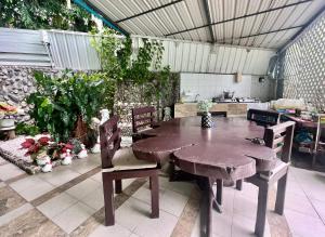 een houten tafel en stoelen in een keuken met planten bij NN Apartment in Pattaya South