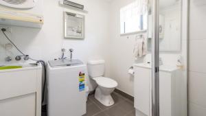 ein weißes Badezimmer mit Toilette und Waschbecken in der Unterkunft Lowset, pet friendly cottage - Sunset Ave, Bongaree in Bellara + 7 Fotos