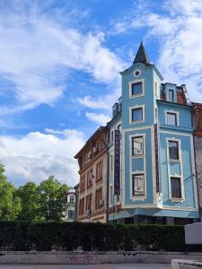 een blauw gebouw met een klok erop bij Aurora Hills Hotel in Plovdiv