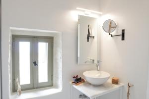 bagno bianco con lavandino e specchio di VILLA CALLIOPE KEA a Ioulida