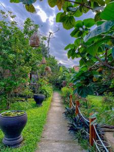 a garden with two large pots and a path at Hue Lotus Homestay in Hue