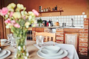 a table with plates and a vase of flowers on it at Spokój i Dobro in Gąski