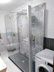 y baño con ducha y lavadora. en The Family Stone House Dolomiti Cortina en Venas