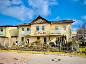 青斯特戈德绑酒店的前面有栅栏的黄色建筑