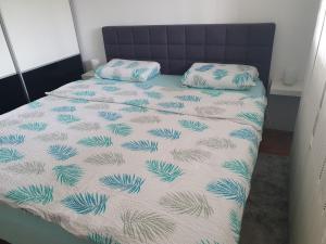 a bed with a blue and white comforter and two pillows at Apartman Džakula in Zagreb