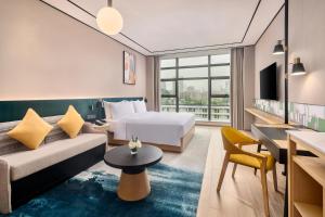 Habitación de hotel con cama y sofá en Hilton Garden Inn Zhuhai Jinan University, en Zhuhai