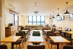 a restaurant with tables and chairs and windows at hotel MONday Tokyo Nishikasai in Tokyo