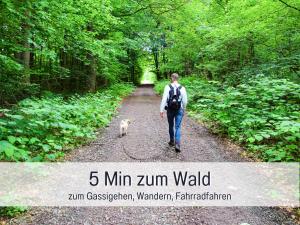 バート・ザクサにあるHaFe Ferienwohnung Bad Sachsa - waldnah, hundefreundlich, Smart Home Ausstattungの未舗装の道を犬歩く男