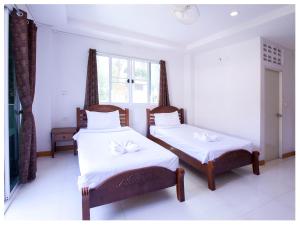 a bedroom with two beds and a window at Namhasin House in Koh Tao