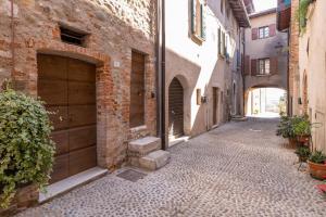 eine Gasse mit zwei Garagentüren und einem Backsteingebäude in der Unterkunft Piero Dry Gin Apartment in bedizzole