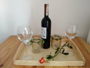 eine Flasche Wein und zwei Gläser auf einem Holztisch in der Unterkunft W Łęgu Natury in Nur
