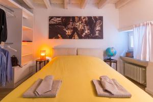 1 dormitorio con 1 cama amarilla grande y 2 toallas en Piero Dry Gin Apartment en bedizzol