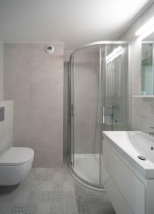 a bathroom with a shower and a toilet and a sink at Milo Aparthotel in Wrocław