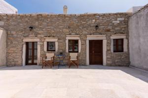 a stone building with two chairs in front of it at Petrino House in Apérathos