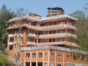 a large brick building with balconies on top of it at Nagarkot Sunshine Hotel in Nagarkot