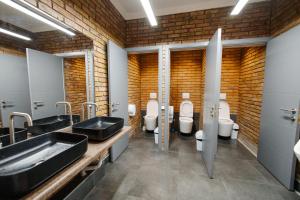 a bathroom with three sinks and four toilets at 281 Hostel in Bishkek