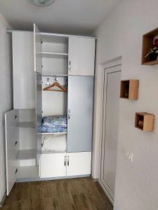 um quarto com armários brancos e uma cama nele em Studio Apartment - Prizren em Prizren