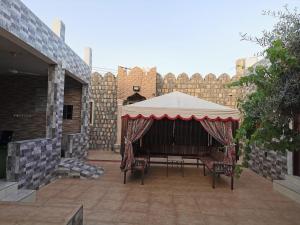 einen Pavillon mit einem Tisch und Stühlen auf einer Terrasse in der Unterkunft Villa Salassel Al Jabal Al Akhdar فلة سلاسل الجبل الأخضر in Al ‘Ayn