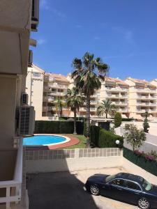 a black car parked in a parking lot in front of a building at Lovely one bedroom unit with balcony and pool in Denia