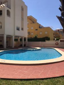 a large swimming pool in front of a building at Lovely one bedroom unit with balcony and pool in Denia